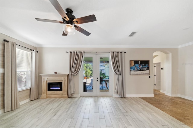 unfurnished living room with plenty of natural light, french doors, ceiling fan, and wood finished floors