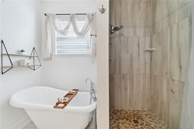 bathroom with tiled shower and a soaking tub