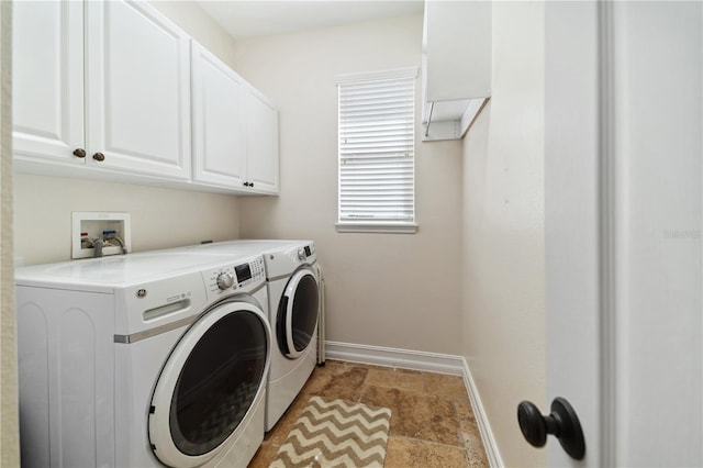 washroom with cabinet space, independent washer and dryer, and baseboards