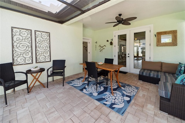 dining area with a ceiling fan, stone finish floor, and french doors