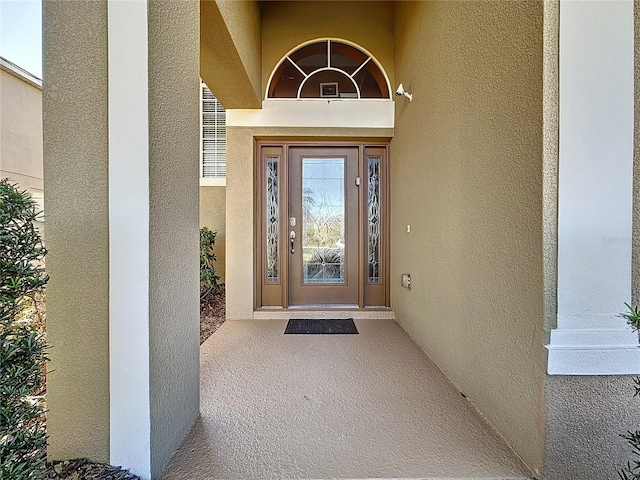 doorway to property featuring stucco siding