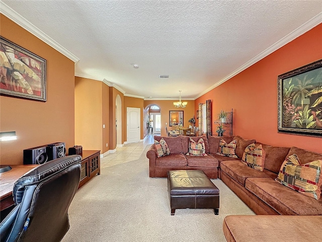 living area featuring an inviting chandelier, arched walkways, ornamental molding, a textured ceiling, and light carpet