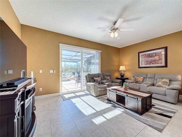 living room featuring light tile patterned floors, baseboards, a sunroom, ceiling fan, and a textured ceiling