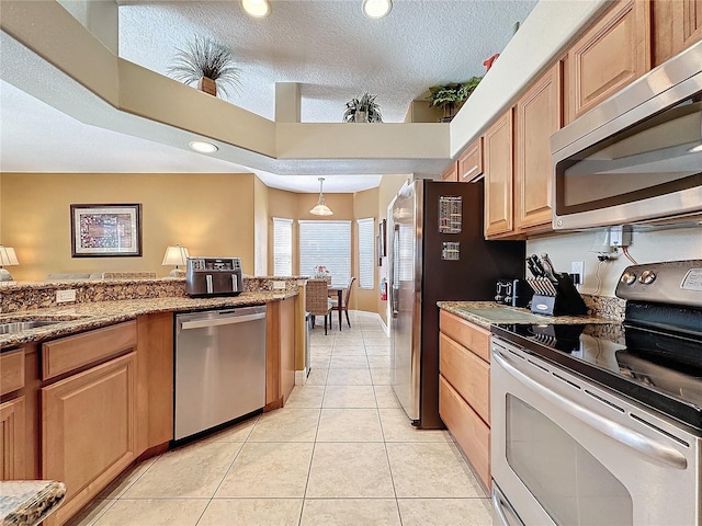 kitchen featuring recessed lighting, stainless steel appliances, a textured ceiling, and light tile patterned flooring