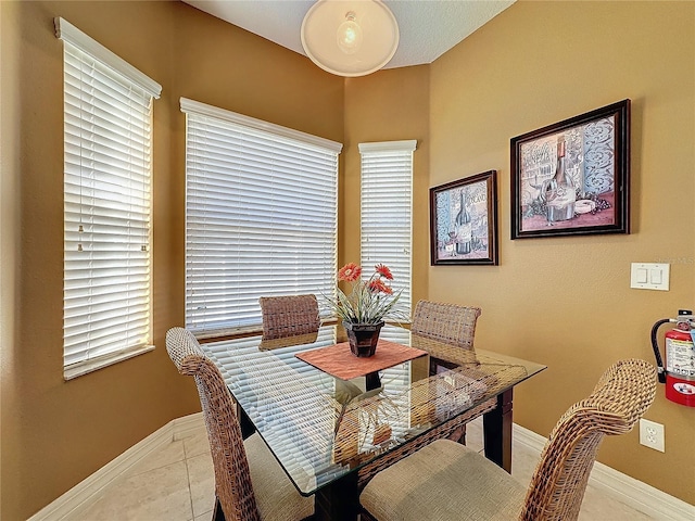 dining room featuring baseboards and light tile patterned flooring