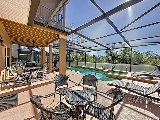 view of pool with a lanai, a pool with connected hot tub, and a patio