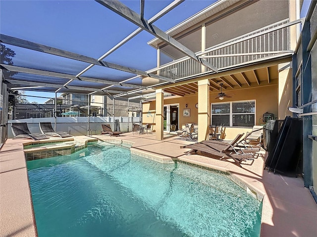 view of pool featuring a lanai, a pool with connected hot tub, a ceiling fan, and a patio