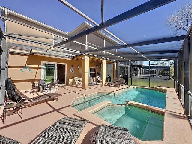 view of pool with a patio area, a pool with connected hot tub, and a lanai