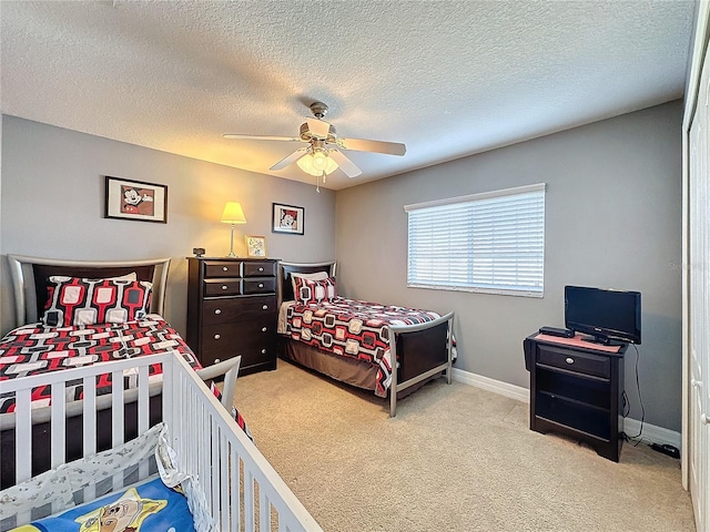 bedroom featuring baseboards, a ceiling fan, carpet flooring, and a textured ceiling