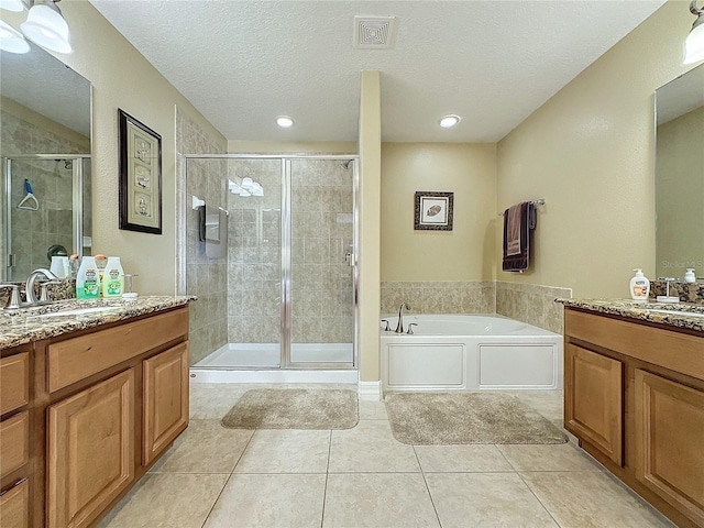 bathroom with two vanities, visible vents, a stall shower, and a sink