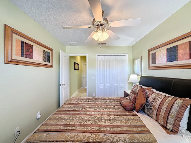 bedroom with visible vents, baseboards, a closet, a textured ceiling, and a ceiling fan