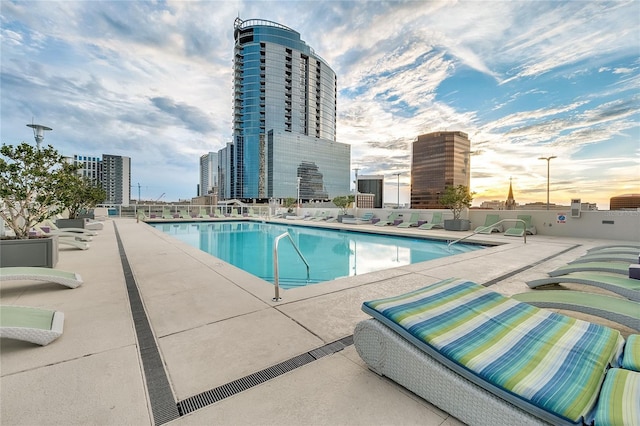 community pool with a view of city and a patio area