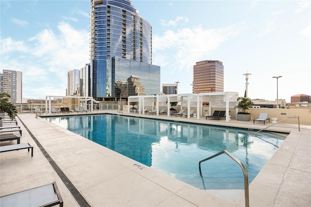 community pool with a patio and a view of city