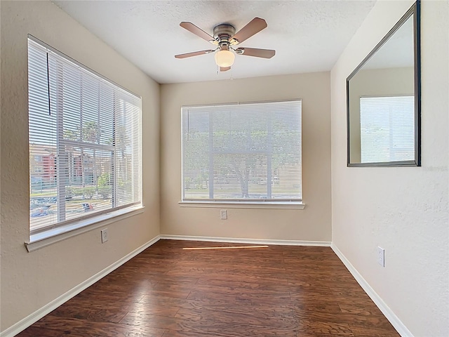 unfurnished room featuring a textured ceiling, wood finished floors, baseboards, and ceiling fan