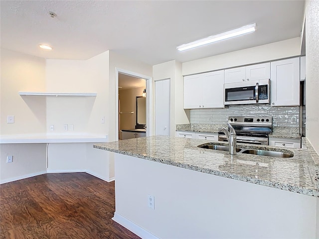 kitchen featuring backsplash, dark wood finished floors, white cabinetry, appliances with stainless steel finishes, and light stone countertops