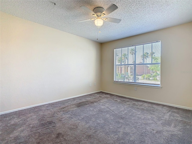 carpeted empty room with a textured ceiling, baseboards, and a ceiling fan