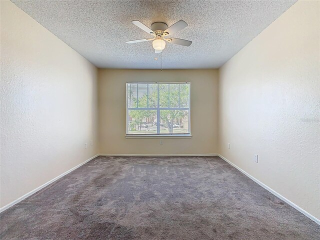 carpeted spare room featuring baseboards, a textured ceiling, a ceiling fan, and a textured wall