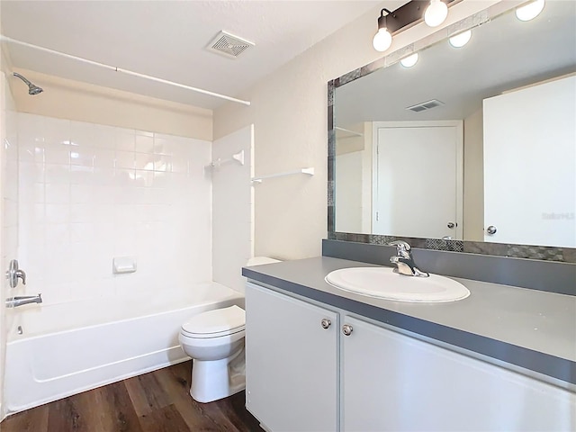 full bath with vanity, washtub / shower combination, wood finished floors, visible vents, and toilet