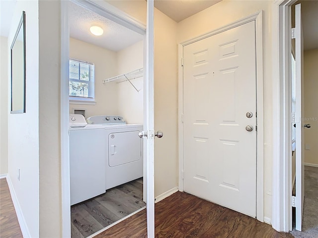 washroom with washing machine and clothes dryer, laundry area, baseboards, and wood finished floors