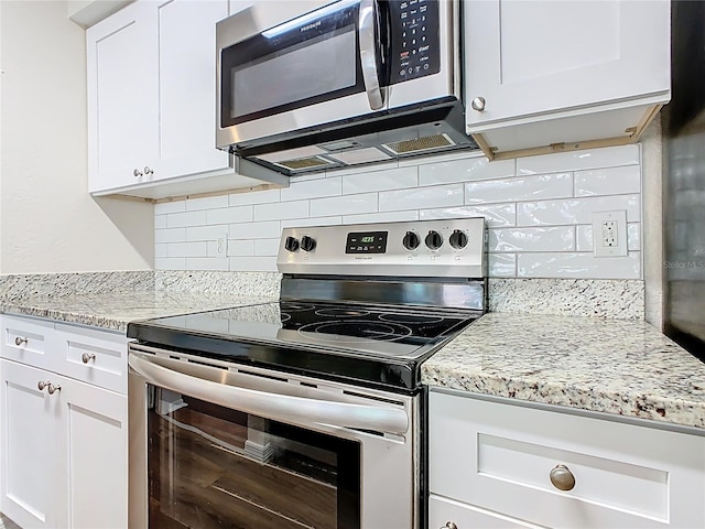 kitchen with decorative backsplash, white cabinets, light stone counters, and stainless steel appliances