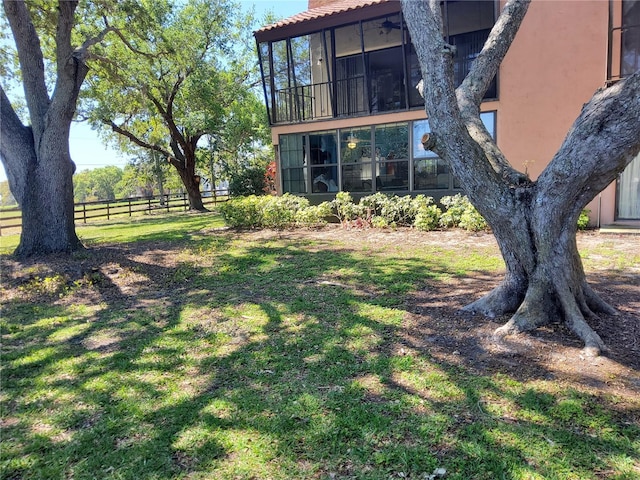 view of yard featuring fence and a sunroom