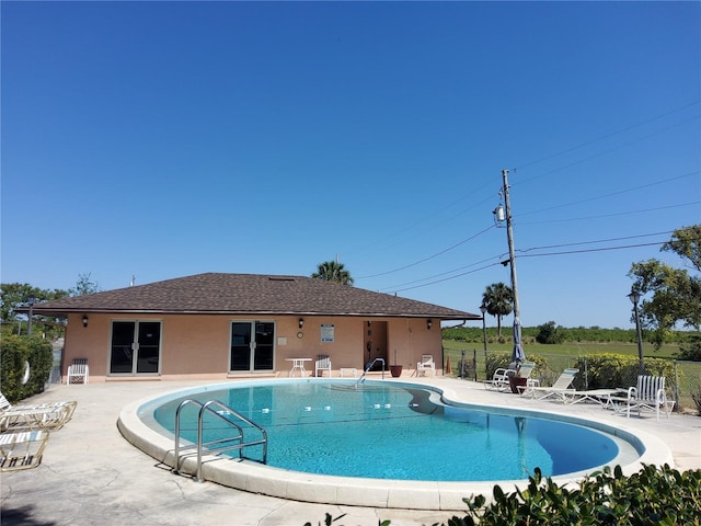 community pool with fence and a patio area