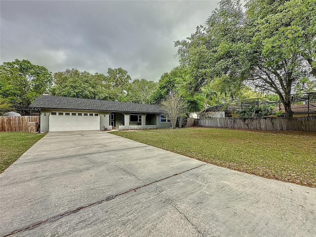 876 Lobster Ct, Kissimmee, FL 34744 - ranch-style home featuring concrete driveway, a garage, fence, and a front yard