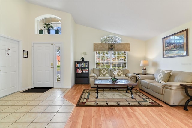 living area with light wood-style flooring and high vaulted ceiling