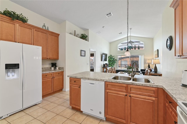 kitchen featuring visible vents, a sink, white appliances, brown cabinetry, and light countertops