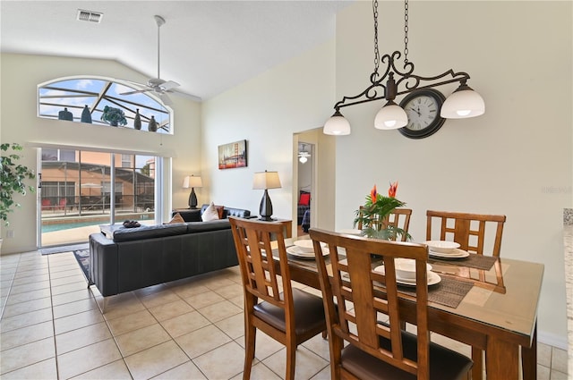 dining area featuring light tile patterned floors, a ceiling fan, visible vents, and high vaulted ceiling