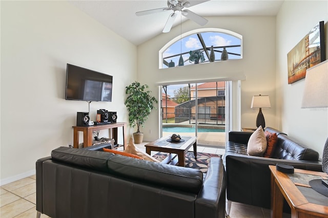 living area with light tile patterned floors, high vaulted ceiling, baseboards, and ceiling fan