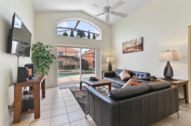 living area with light tile patterned flooring, high vaulted ceiling, and a ceiling fan