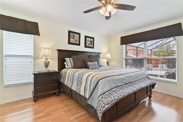 bedroom with a ceiling fan, baseboards, and light wood-type flooring