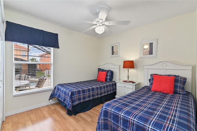 bedroom featuring a ceiling fan, wood finished floors, and baseboards