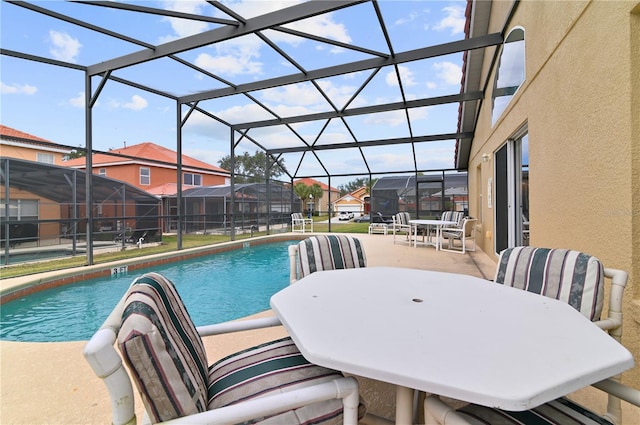 outdoor pool featuring glass enclosure, a patio, and outdoor dining space