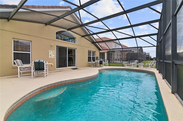 pool with a lanai and a patio area