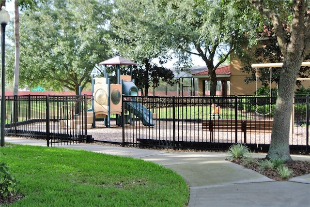 community play area featuring fence and a lawn