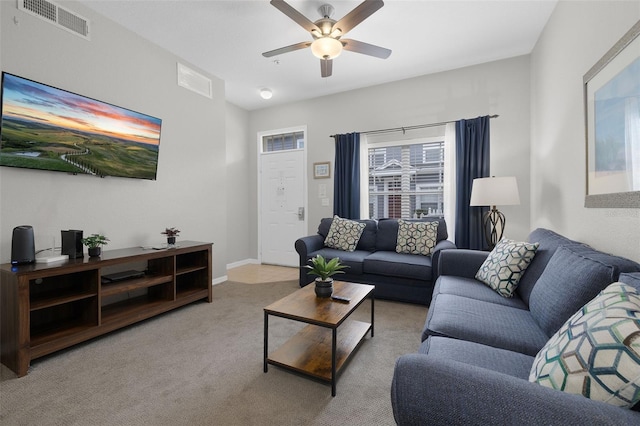 living area featuring visible vents, baseboards, a ceiling fan, and carpet flooring