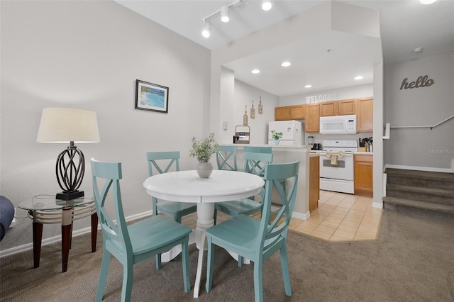 dining room featuring stairs, rail lighting, baseboards, and light carpet