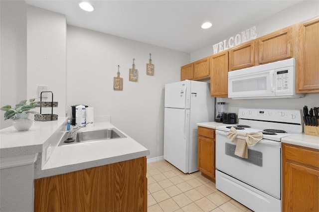 kitchen with a sink, white appliances, recessed lighting, and light countertops