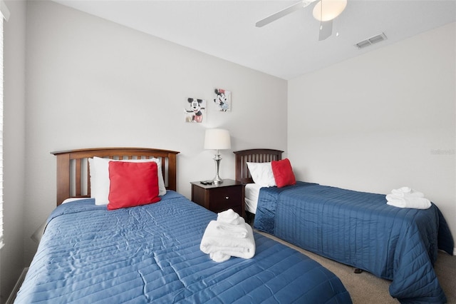 carpeted bedroom featuring visible vents and a ceiling fan