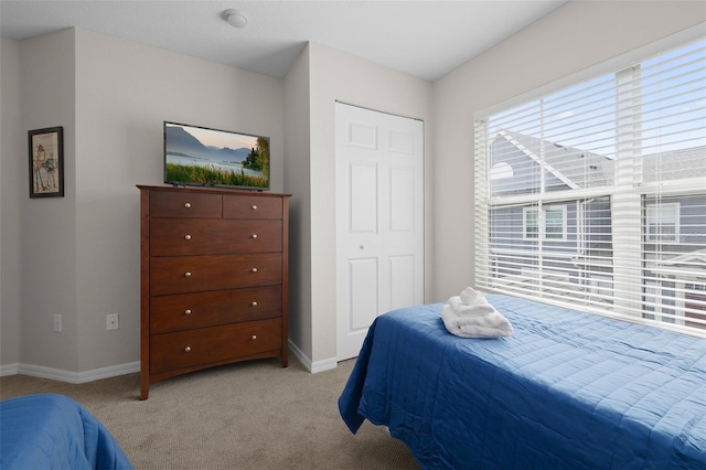 bedroom featuring baseboards and light colored carpet