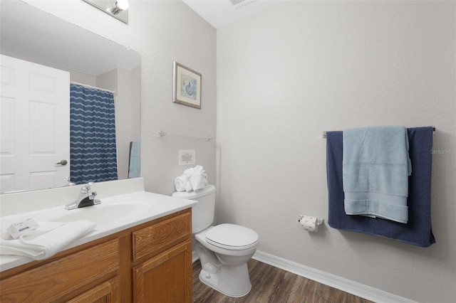 bathroom with a shower with curtain, toilet, wood finished floors, baseboards, and vanity