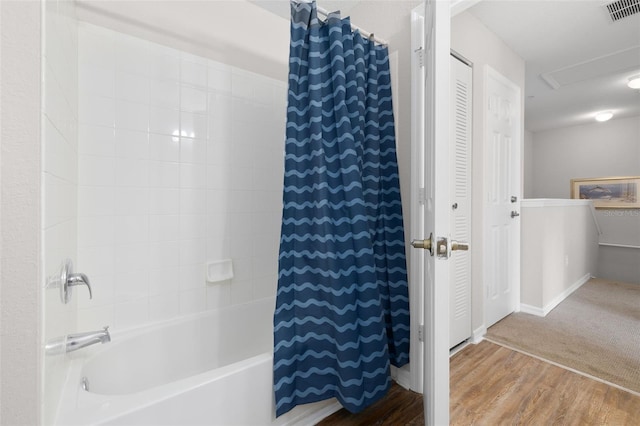 bathroom featuring wood finished floors, visible vents, baseboards, a closet, and shower / tub combo with curtain