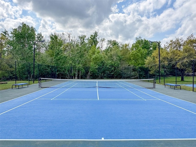 view of tennis court featuring fence