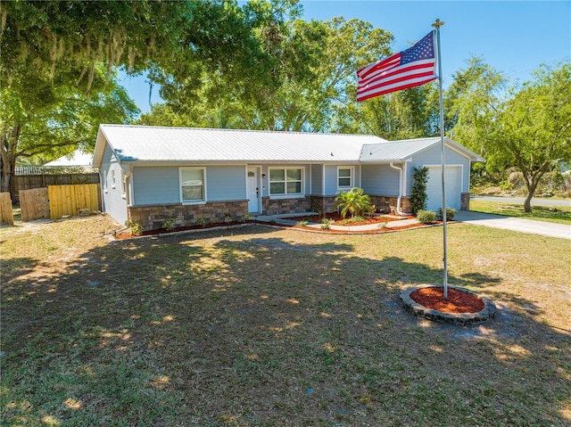 ranch-style home with stone siding, metal roof, a garage, and fence