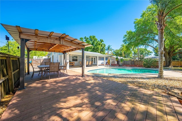 view of swimming pool featuring a deck, outdoor dining space, a fenced backyard, and a fenced in pool