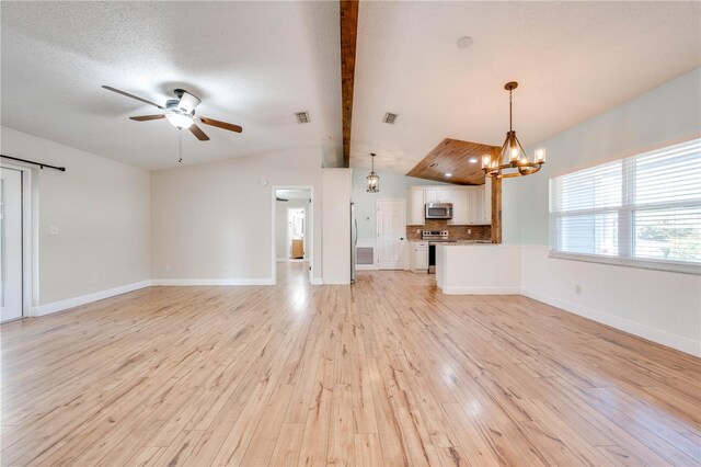 unfurnished living room featuring visible vents, ceiling fan with notable chandelier, vaulted ceiling with beams, and light wood finished floors