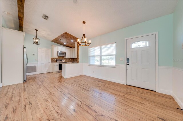 kitchen featuring visible vents, a chandelier, light wood-style flooring, appliances with stainless steel finishes, and white cabinets