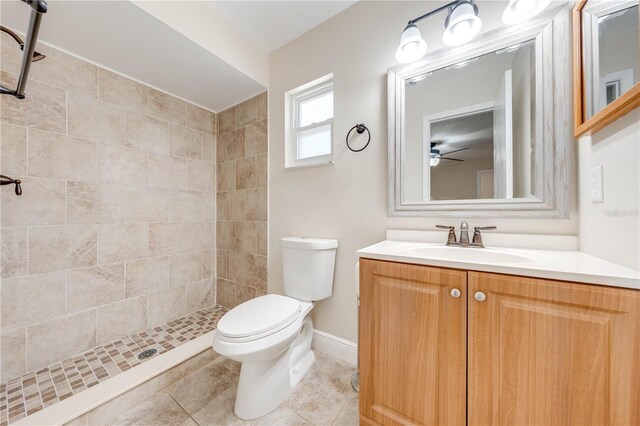 bathroom featuring vanity, baseboards, a stall shower, tile patterned flooring, and toilet